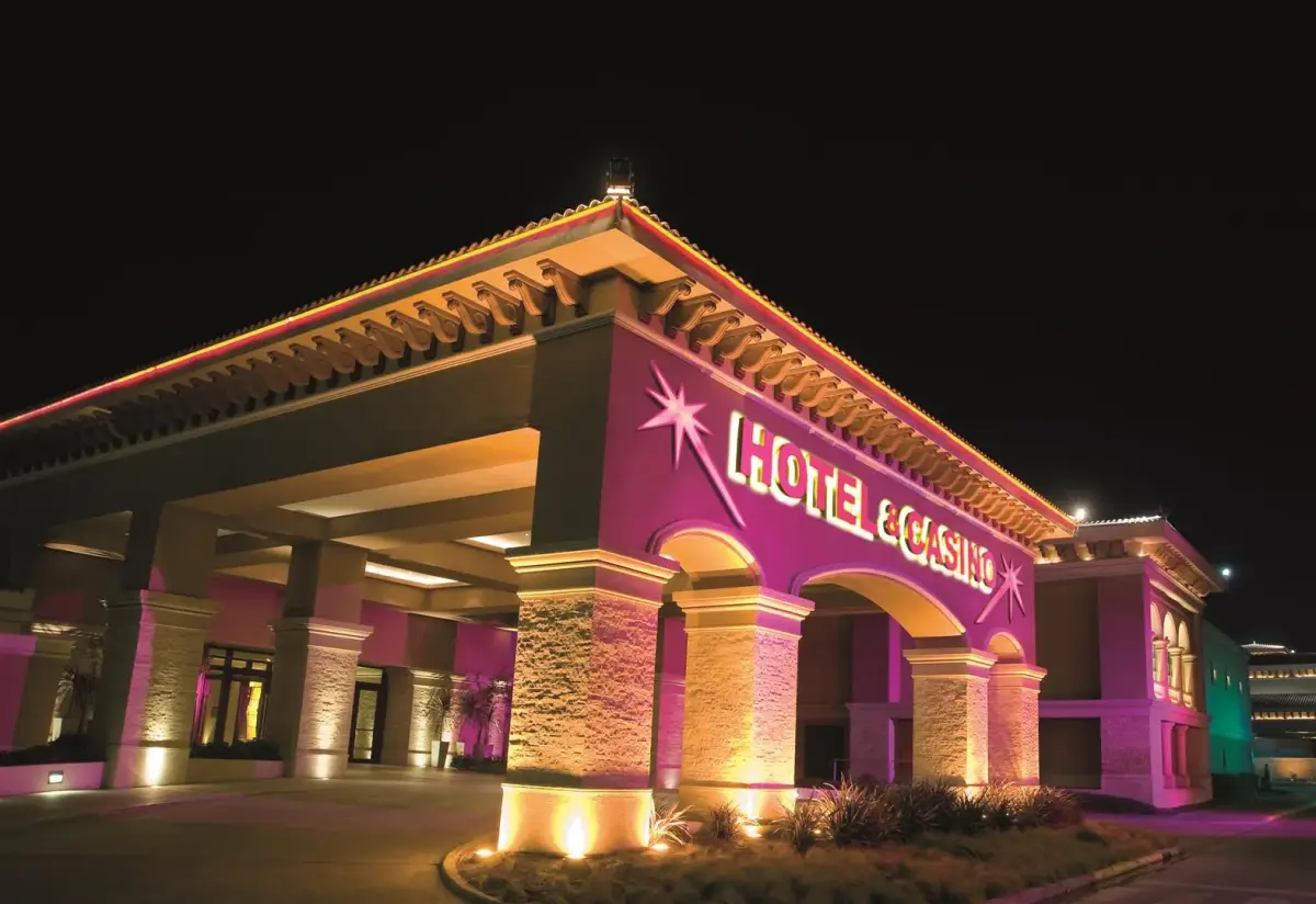 Entrada del hotel y casino iluminada de noche, con el rótulo Hotel & Casino